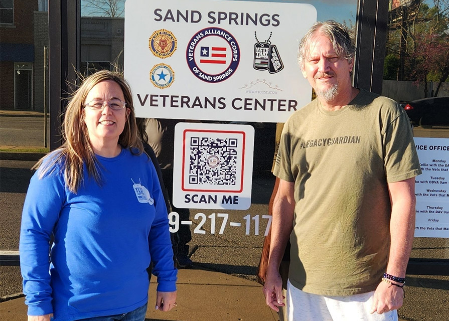 Woman and man stand in front of veterans center