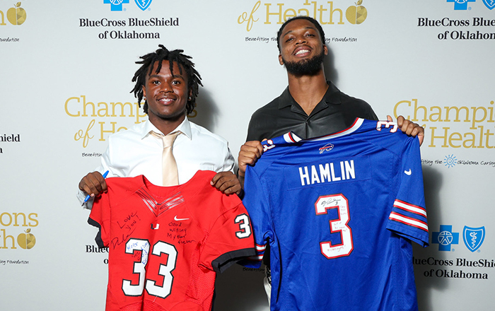 Union High School student Dae’Mar Nealy and Damar Hamlin of the Buffalo Bills pose after swapping football jerseys