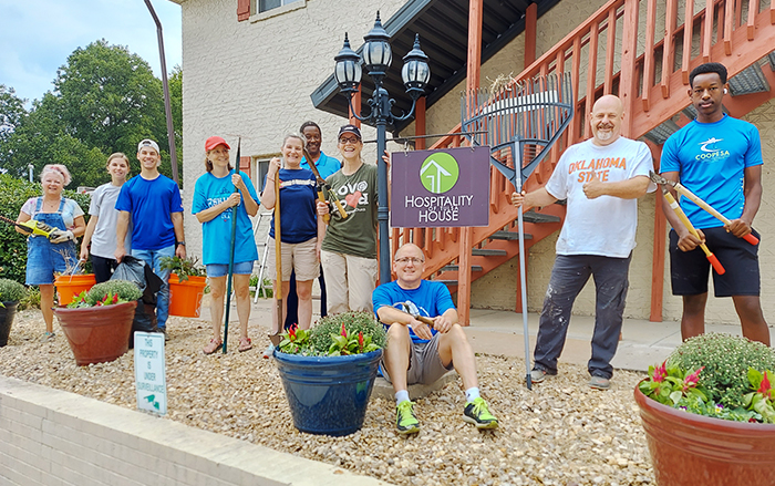 Volunteer partners pose with landscaping tools