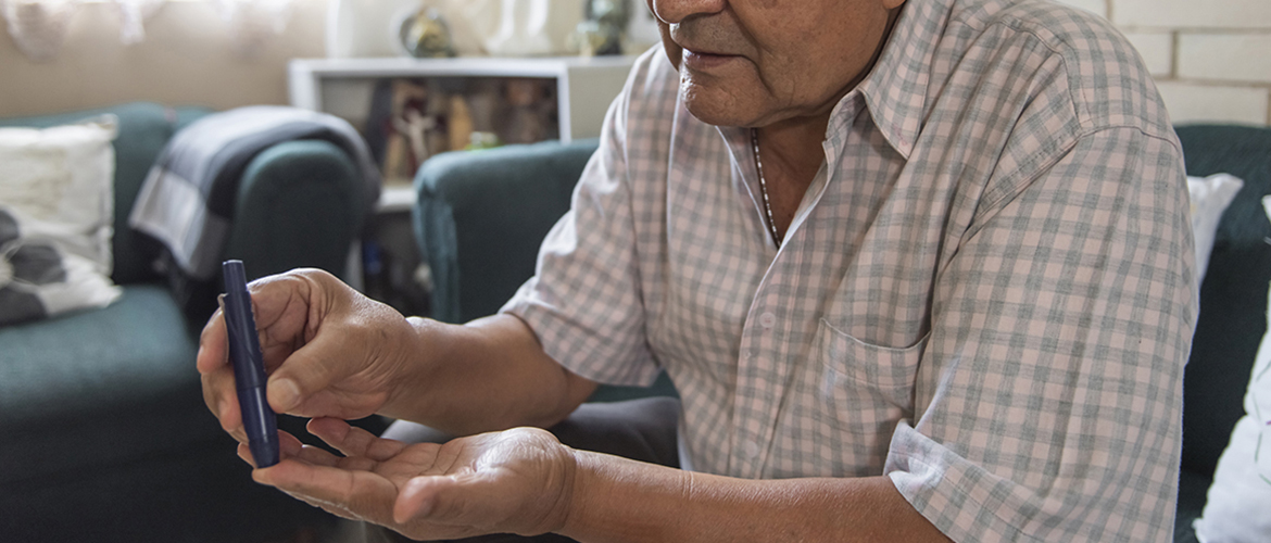 Man pricks his finger to check his blood sugar level for diabetes management