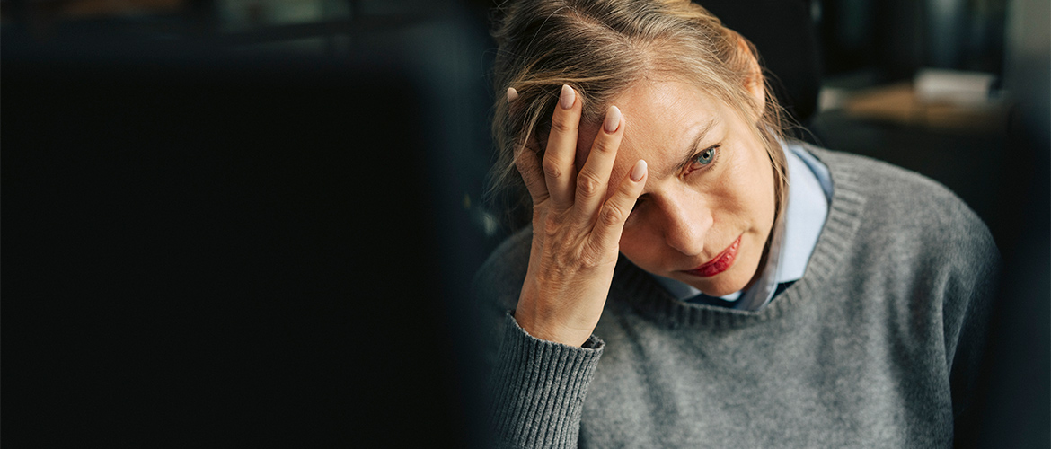 Woman holds her head in her hand