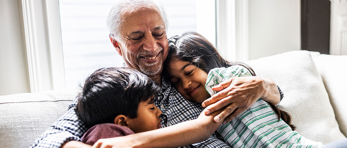 Man sits closely with two children, one on each side