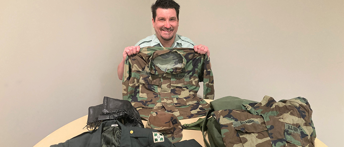 BCBSOK employee and U.S. Army veteran holds up his uniform