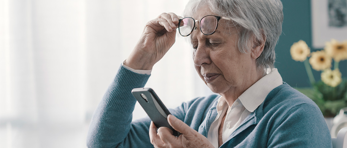 Woman lifts her eyeglasses to read her smart phone