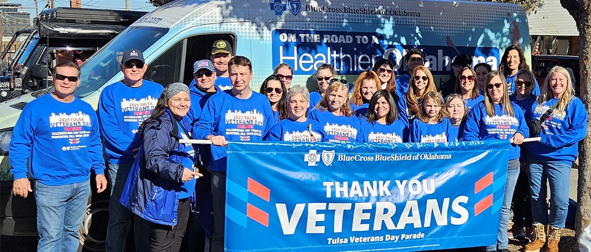 People march behind banner in Tulsa veterans parade