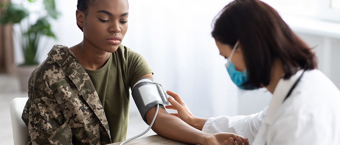 A health care worker takes a woman's blood pressure