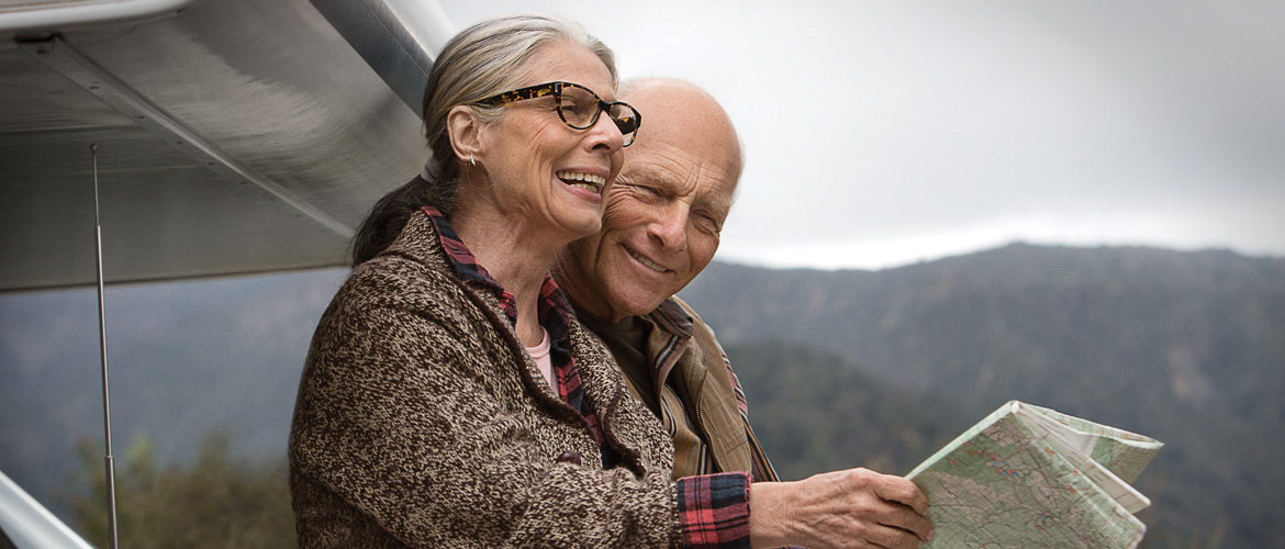 Older couple looks at map while traveling outdoors