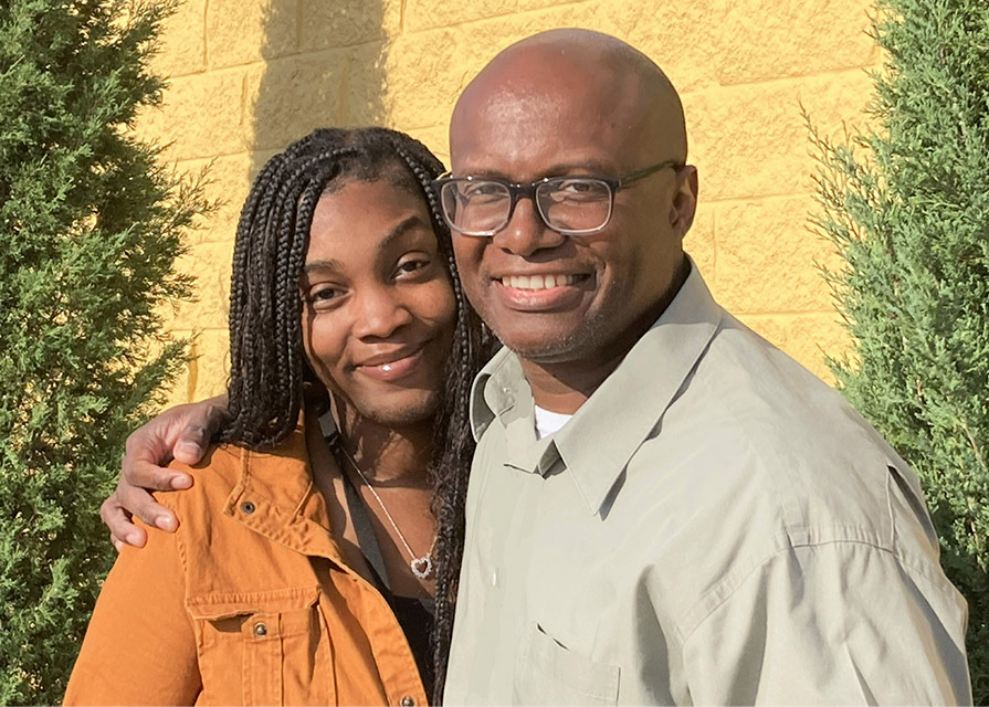 Older father has his arm around the shoulders of adult daughter 