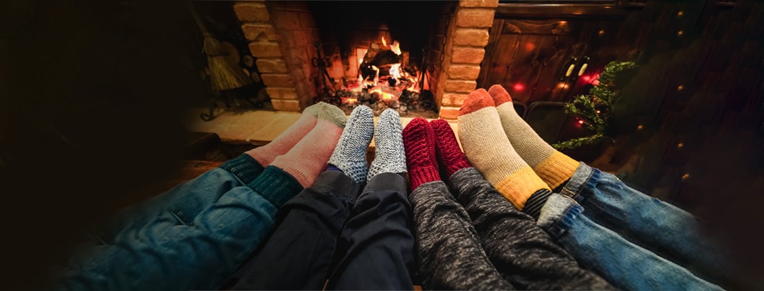 Feet in cozy socks around a fireplace