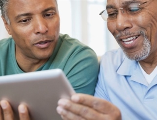 Dos hombres de mediana edad mirando juntos un iPad