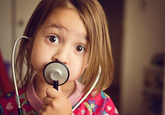 Una niña bonita hablando con un estetoscopio