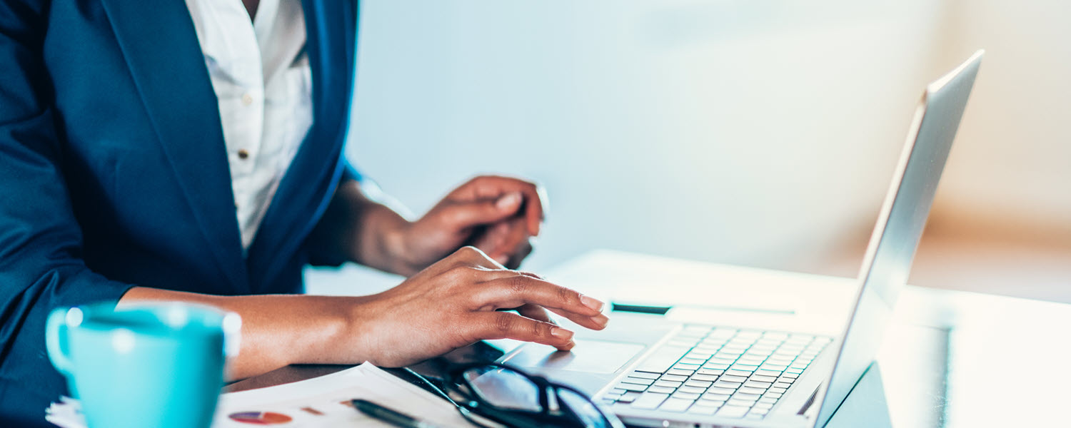 Employer at desk paying bills on laptop