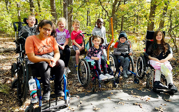 Physically challenged kids outdoors in the woods.