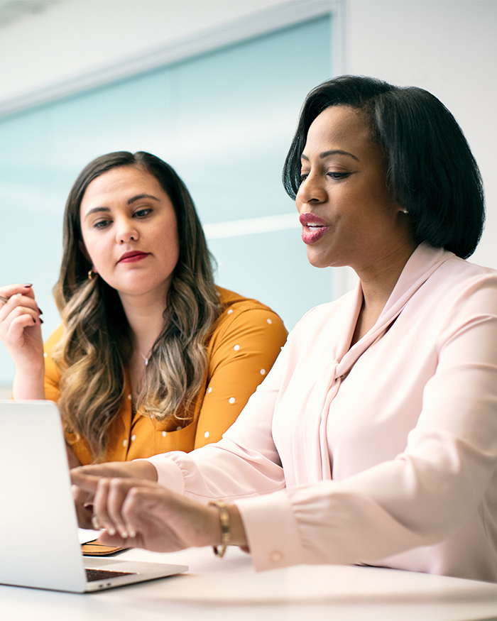 Two well-dressed women discuss business