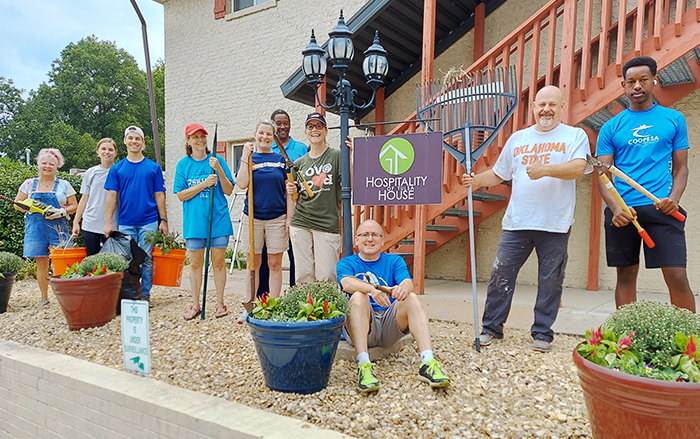 Socios voluntarios posan con herramientas de jardinería