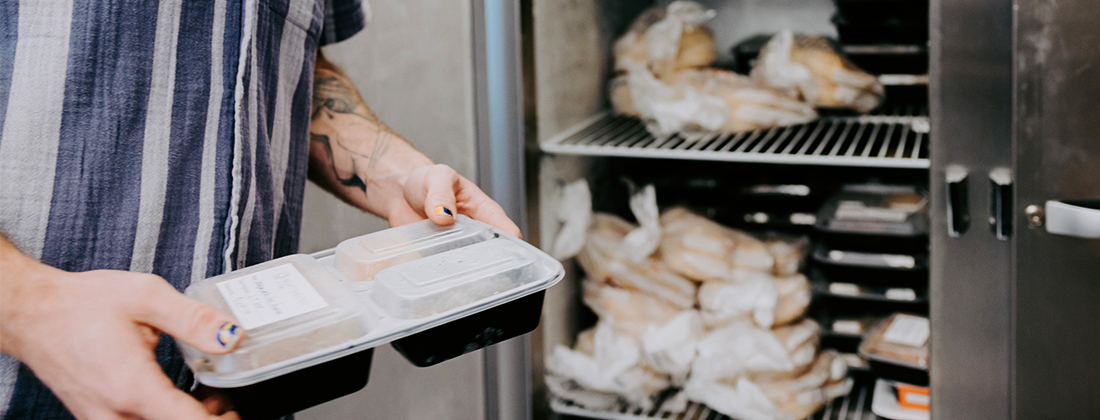 Prepared meals being put into refrigerator