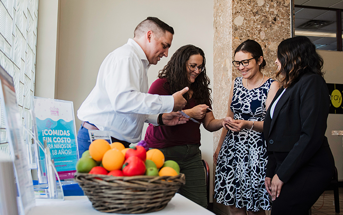 Employees showing community members an informational pamphlet