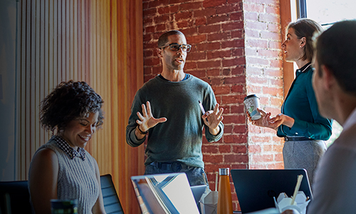 A diverse group of workers collaborate together in office space