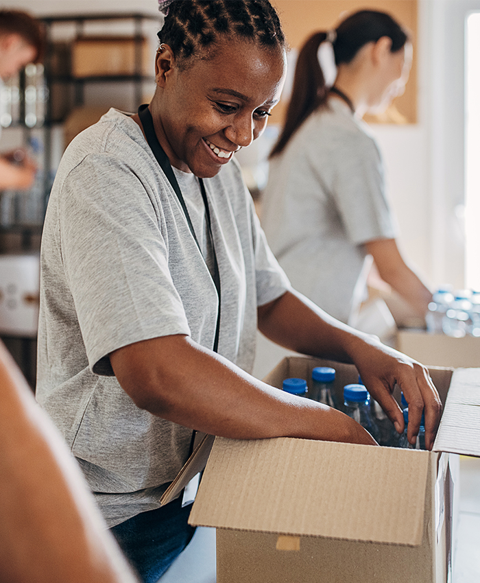 Voluntario clasifica productos en caja de donaciones