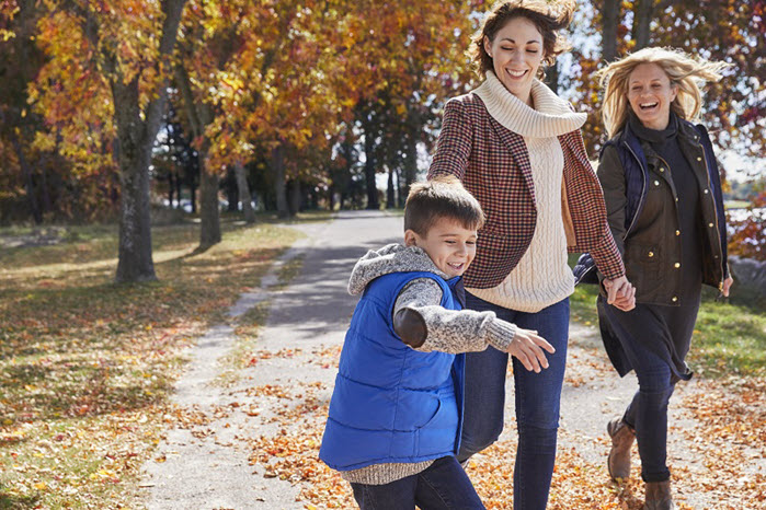 Family walking through the park during fall