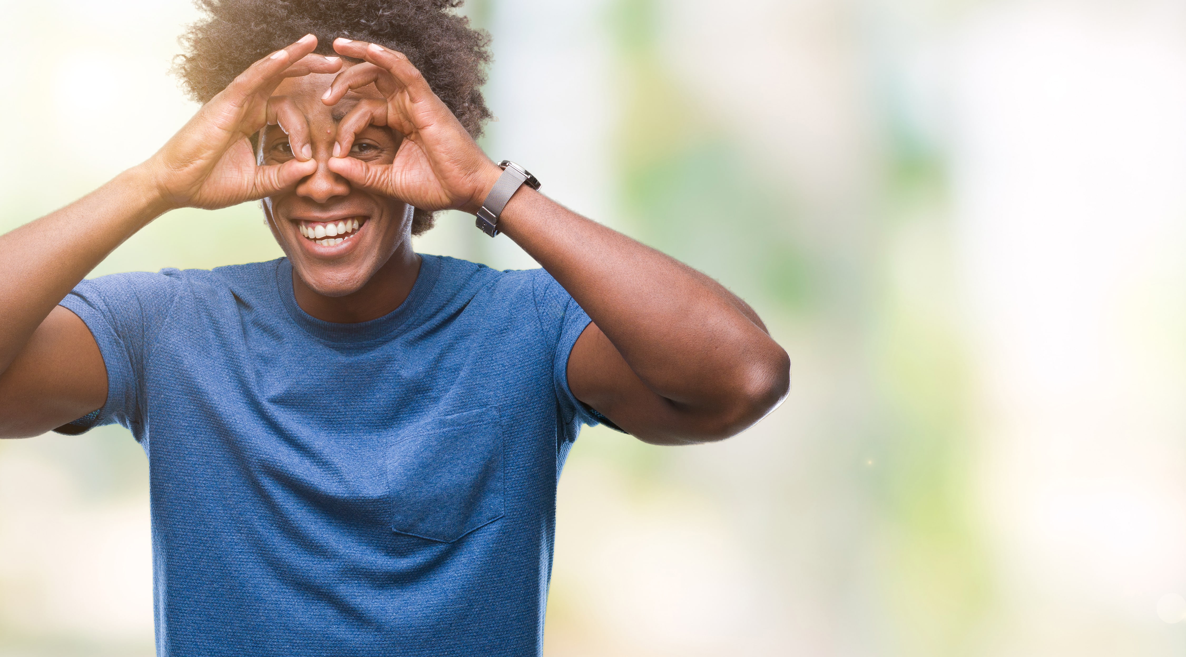 Hombre haciendo forma de anteojos con las manos sobre los ojos