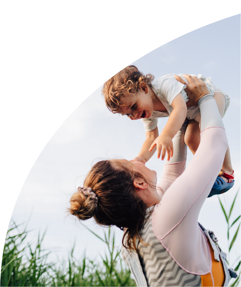 Mother lifting child into the air. 